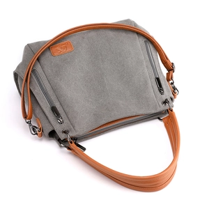 Grey canvas tote bag with brown leather handles and multi-zipper pockets on white background