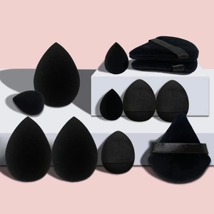 Detailed set of black makeup sponges in teardrop, oval, and triangle shapes on a stand
