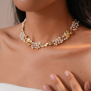 Detailed close-up of golden leaf necklace with faux pearls in vintage palace style