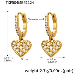 Detailed view of gold heart earrings with zircon inlay and stainless steel texture