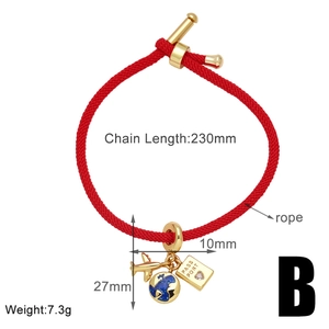 Dettaglio del bracciale rosso con ciondoli dorati a forma di aereo, globo e passaporto