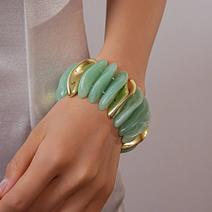 Detail of mint green marble acrylic tiles and polished gold metal parts on elastic bracelet