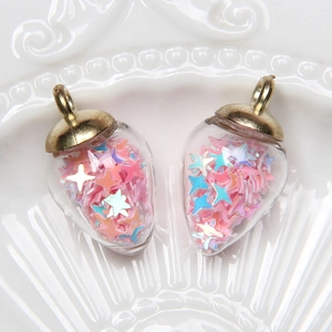 Detail of strawberry-shaped glass pendants with pink and blue star sequins and gold caps