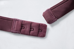 Dettaglio della chiusura regolabile a tre file su un reggiseno in pizzo viola scuro