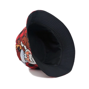 Detail of reversible Christmas bucket hat featuring red plaid and Santa Claus patterns