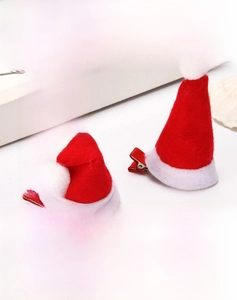 Close-up of mini red felt Christmas hat hair clips with white faux fur pompom and trim
