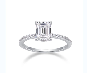 Macro shot of an emerald-cut moissanite ring with a sparkling pavé setting in 925 silver