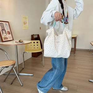Quilted floral canvas tote bag with blue rabbit pattern shown in a cafe setting