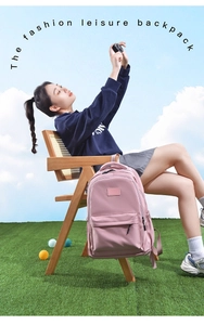 Pink casual nylon backpack for students shown in an outdoor lifestyle setting on a chair