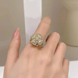 Rotating gold four-leaf clover ring with micro-set zircons on a woman's finger