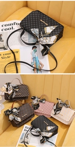 Close-up of embossed texture and silk scarf handle on stylish small square bags