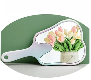 Close-up of wave-shaped handheld makeup mirror with gradient metallic finish and tulip reflection