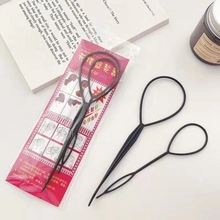 Detail view of black flexible plastic hair braiding tool kit with usage instructions