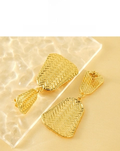 Detail of gold geometric earrings with woven texture and 18K plated metal finish