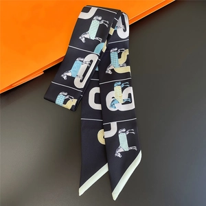 Elegant black silk twilly scarf featuring horse motifs and geometric patterns on orange stand