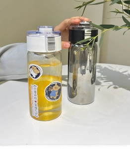 Detail of portable plastic water bottles with secure lock lids and cute dog stickers