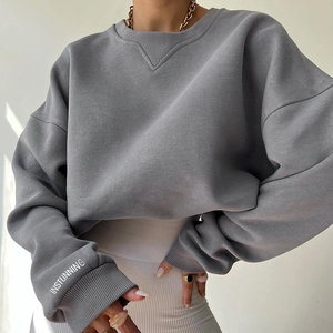 Detail of loose dark grey sweatshirt featuring V-ribbed neck and white sleeve print