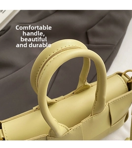 Dettaglio della trama in pelle intrecciata e cuciture del manico della borsa gialla