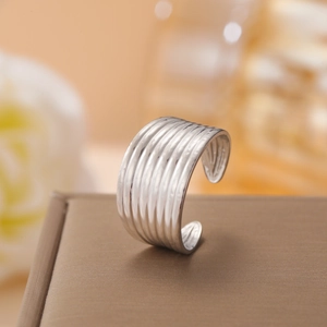 Polished silver textured stainless steel open ring displayed on a brown jewelry box