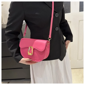Detailed side view of pink semi-circular saddle bag with golden metal buckle on model