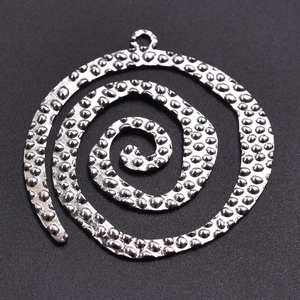 Macro shot of silver spiral stainless steel pendant with textured surface detail