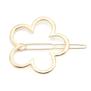 Golden hollow flower hair clip in minimalist metal alloy design on white background
