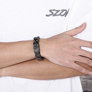 Detail of a wide vintage steel punk bracelet featuring skull and crossbone links on wrist