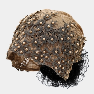 Détail d'un turban en dentelle florale marron orné de perles et bordure en dentelle