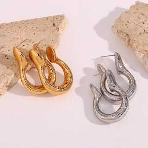 Detailed view of textured hollow irregular geometric earrings in gold and silver finish