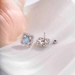 Elegant silver flower stud earrings with light blue gemstone and clear zircon accents