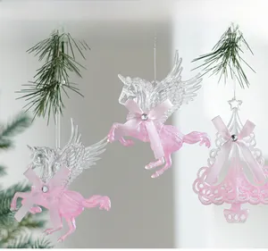 Macro detail of pink glitter unicorn and filigree tree ornaments on green pine branches