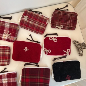 Detail of red plaid wool coin purses with embroidered bows and tassel zippers