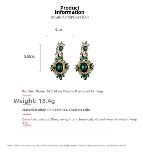 Detail view of emerald green crystal earrings with silver needles and rhinestones