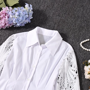 Close-up of elegant white long sleeve shirt with lace patchwork and turn-down collar