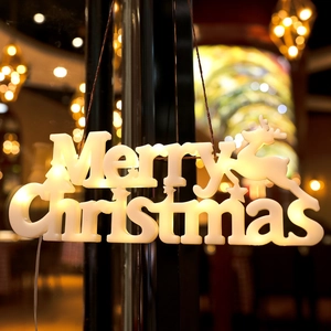 Dettaglio lampada LED Merry Christmas bianco caldo con renna e stelle decorative