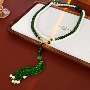 Détail du collier à pampilles en perles de cristal de nuage sur plateau en bois