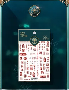 Close-up of Chinese calligraphy nail stickers with red characters and gold motifs