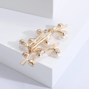 Detailed back view of gold flower brooch showing pin and clasp mechanism with pearls