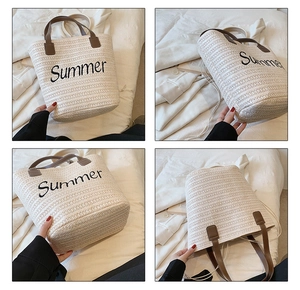 Detail view of woven straw tote bag with Summer embroidery and leather handles