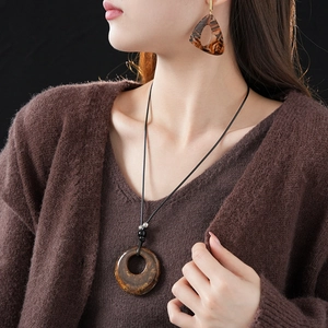 Leopard print resin necklace and earrings set worn with a brown knit cardigan