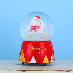 Close-up of a Christmas snow globe featuring Santa Claus and reindeer on a red base