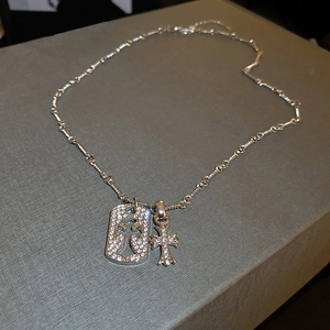 Macro detail of silver cross pendant and military tag with sparkling crystals