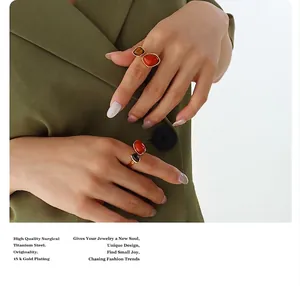 Detail showing 18K gold plated titanium ring with natural red stone on model's hand