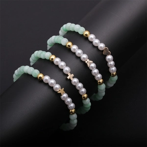 Ensemble de quatre bracelets à perles avec charms cœur et papillon en vert et doré