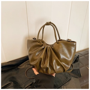 Macro shot of dark olive pleated cloud handbag featuring shiny soft leather texture