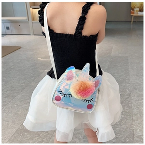 Dettaglio della borsa a tracolla unicorno argento con pompon colorato su gonna bianca