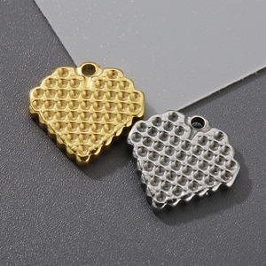 Detailed macro view of heart-shaped honeycomb pendants in gold and silver stainless steel
