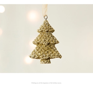 Détail macro d'une suspension sapin de Noël doré champagne avec paillettes et ruban