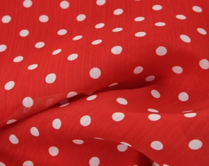 Nahaufnahme von rotem Polka-Dot-Stoff mit feinen Rüschen und weicher Textur