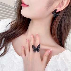 Detail view of a black butterfly jewelry set featuring sparkling stud earrings and ring
